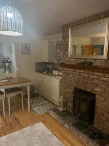 恩尼斯基林Laraghson House的厨房配有砖砌壁炉、桌子和用餐室