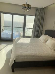 吉达Damac Al Jawharah Tower Apartments的一间卧室配有一张大床和一个吊灯。