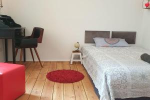 不莱梅Exklusive 3-Zimmer-Wohnung, 2 Ebenen, Messe, Zentrum, 67 m2的一间卧室配有床、钢琴和红色地毯