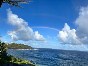 帕霍阿Ocean View Black Sand Beach House @ Kehena beach HI的天空中的彩虹