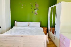塞费塔尔New living Home的卧室配有白色的床和绿色的墙壁