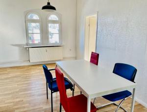 塞费塔尔New living Home的一间设有白色桌子和蓝色椅子的客房