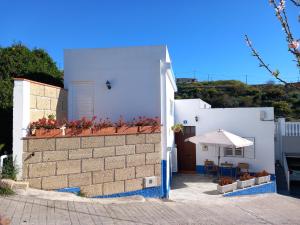 FasniaCASA ISABEL - (ZONA RURAL)的白色的房子,设有庭院和遮阳伞