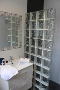 桑坦德利亚湾Hotel Bahia的一间带水槽和玻璃架墙的浴室