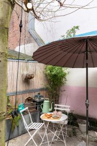阿姆斯特丹环保妈妈旅舍的一张桌子和两把椅子以及一把雨伞