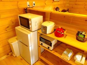 阿苏市藤のヴィラ チェリー棟 Self Check-in的烤面包机旁冰箱上方的微波炉