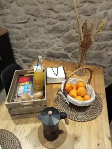 帕德隆A Casiña da Ponte的一张桌子,上面放着一篮橘子和一瓶果汁