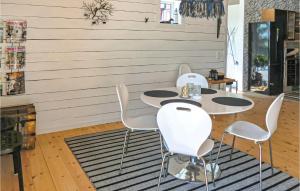 卡尔马Amazing Home In Kalmar With House Sea View的一间设有三张桌子和白色椅子的房间