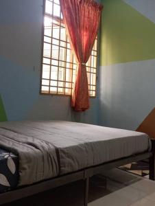哥打巴鲁Nafili homestay 3bd 2br的一间卧室配有一张床和一个带红色窗帘的窗户