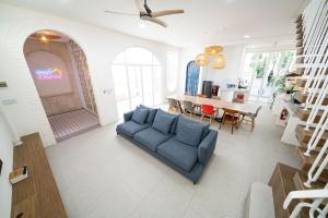 万隆IMAH DHARMA的一间带蓝色沙发的客厅和一间用餐室