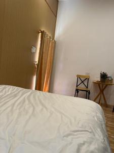 波来古市Pleiku Homestay的卧室配有白色的床和窗户。