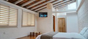 巴尼奥斯Rústic Quinta La Aurora的卧室配有一张床,墙上配有电视。