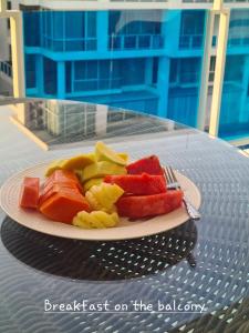 华欣Light, airy, pool views 2 bed 2 bath, free wifi, elect的桌上一盘水果,有叉子