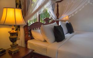 康提Ceylon Breeze的一间卧室配有一张带台灯的床铺,