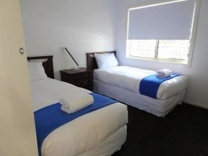 科夫斯港阿夸露娜海景度假屋的酒店客房设有两张床和窗户。