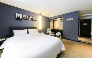全州市KAMA Hotel的卧室配有白色的床和蓝色的墙壁