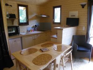 Saint-MaxireLe Chalet du Chloris的一个带木桌和椅子的小厨房