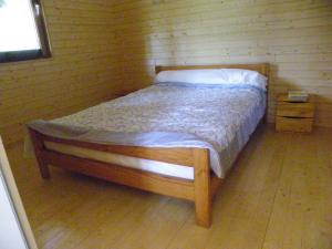 Saint-MaxireLe Chalet du Chloris的木地板客房的一张床位
