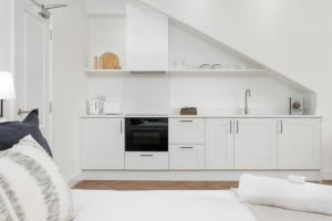 利物浦40 Renshaw Apartments的白色的厨房配有白色橱柜和炉灶。