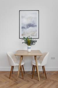 利物浦40 Renshaw Apartments的一张带椅子的木桌和一个花瓶