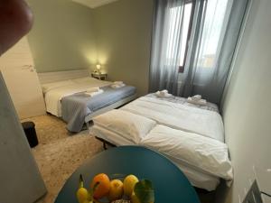 比萨Dal Ciandri的一间设有两张床的房间和一张带水果的桌子