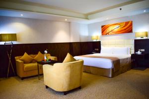 马斯喀特The Secure Inn Hotel Muscat的配有一张床和一把椅子的酒店客房