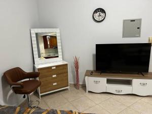 迪拜Rayyan Stays的客厅配有平面电视和椅子。