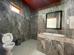 图克图克Juma cottages的一间带卫生间、水槽和镜子的浴室