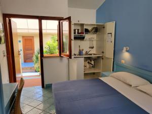 阿格罗波利大森纳酒店的一间蓝色卧室,配有一张床和一间厨房