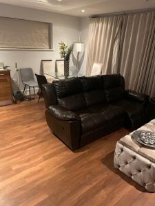 史丹摩Luxurious Furnished Property的客厅配有黑色真皮沙发和桌子