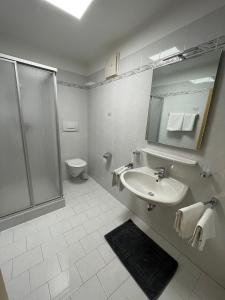拉古多Blummerhof的带淋浴和盥洗盆的白色浴室