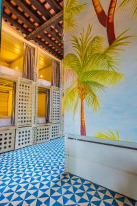 圣玛尔塔República Bahía Santa Marta Hostel的墙上有一棵棕榈树壁画的房间