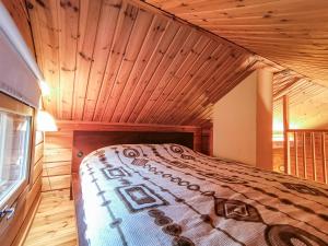NurmijärviPeaceful log cabin in the country的木天花板的客房内的一张床位
