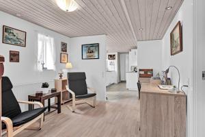 凯特明讷Guldbergs Guesthouse的客厅拥有白色的墙壁和木制天花板。