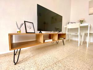 埃希哈Dúplex en pleno centro de Écija的客厅配有木桌上的电视