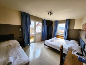 ŽirovnicaPension Knafel的酒店客房设有两张床、一张桌子和窗户。