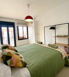 埃希哈Dúplex en pleno centro de Écija的一间卧室配有带枕头的大型绿床