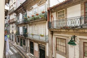 波尔图Sunny Oporto, Douro Apartments的带阳台的小巷和大楼的绿钟