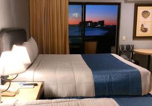 佩尼亚斯科港Peñasco del Sol Hotel的配有一张床、一张书桌和一扇窗户的酒店客房