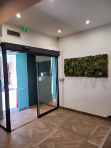 马赛Hotel Le M的办公室大厅,墙上挂着植物,设有一扇开放式门