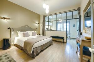 卡尔卡松佩蒂克罗酒店的一间卧室设有一张大床和一个大窗户