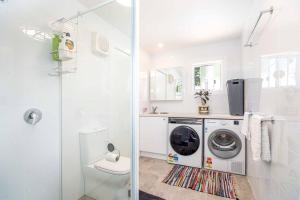 奥兰治The Compact Cube - One-Bedroom Apartment on Summer的白色的浴室设有洗衣机和淋浴。