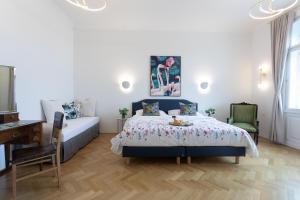 维也纳BOUTIQUE RESIDENCES at GAUDENZDORFER的一间卧室配有一张床、一张桌子和一张沙发