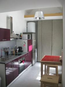 布鲁瓦maisonette cosy Blois的厨房配有紫色橱柜和桌子