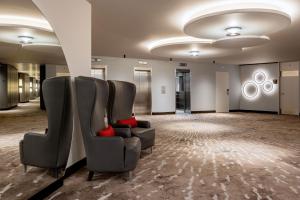 巴塞尔Basel Marriott Hotel的一间设有两张椅子和红色座椅的等候室