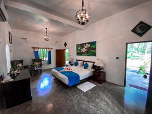 坦加拉红树林海滩小屋酒店的一间设有床铺的大卧室和一间客厅