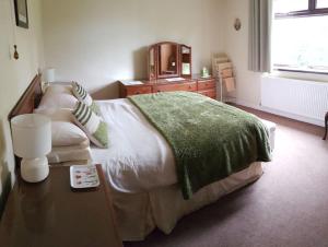 SoutergateHalsteads: peaceful location, stunning views的一间卧室配有一张大床和一张桌子