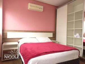 弗洛里亚诺波利斯Residencial Nicole的卧室设有红色的墙壁和一张床
