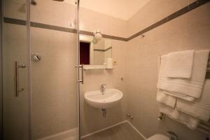 佛罗伦萨奈拉酒店的浴室配有盥洗盆、淋浴和毛巾