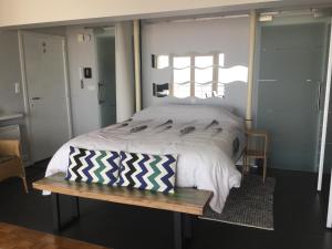 奥斯坦德Royal Zeezicht Oostende的一间卧室配有一张大床和木凳